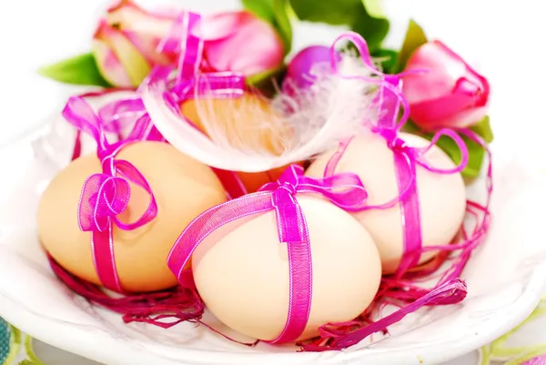 Великодні яйця з рожевою стрічкою на тарілці — стокове фото