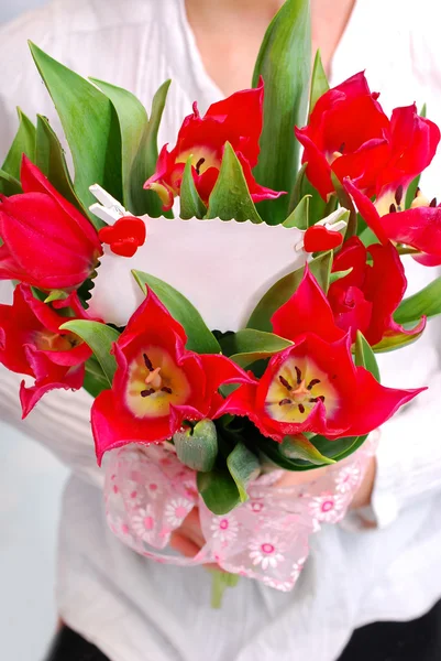 Букет красных тюльпанов с билетом на сообщение — стоковое фото