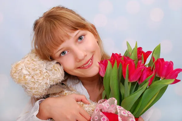 Beautiful girl with teddy bear and tulips — Stock Photo, Image