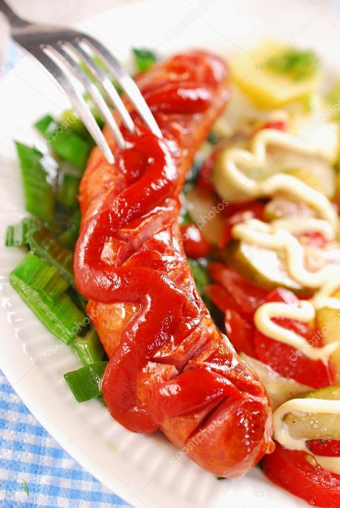 grilled sausage with ketchup and vegetable salad