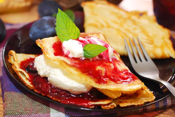 Pancakes with plum confiture and whipped cream — Stock Photo, Image