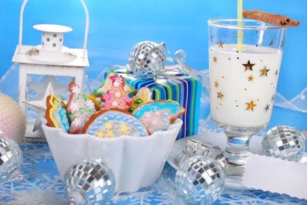 Biscoitos de gengibre coloridos e vidro de leite para Papai Noel — Fotografia de Stock