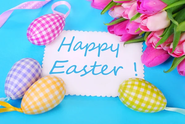 Huevos de Pascua con tarjeta de felicitación y tulipanes —  Fotos de Stock