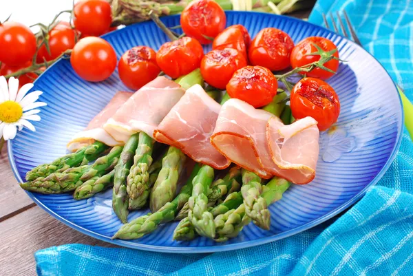 Espargos verdes com presunto e tomate cereja grelhado — Fotografia de Stock