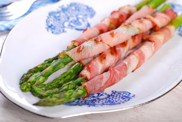 Grilled green asparagus wrapped in bacon — стоковое фото