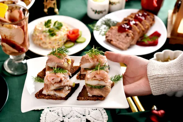 Uma Mão Segurando Uma Placa Com Mini Canapés Com Arenques — Fotografia de Stock