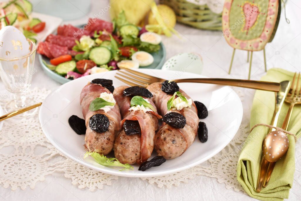 Easter table with grilled white sausage wrapped in bacon with prune and horseradish