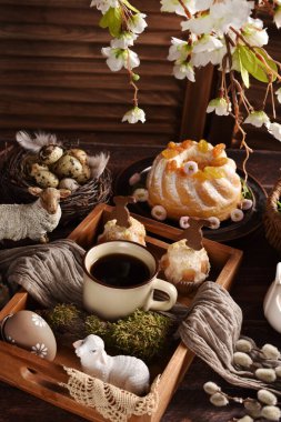 Bir fincan kahve ve paskalya pastası ahşap masanın üstünde, kırsal tarzda. 