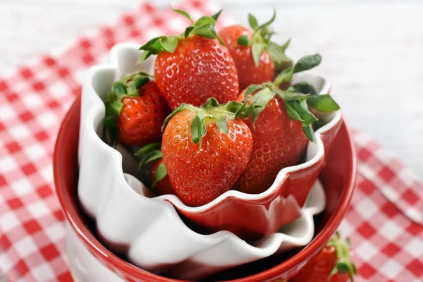桌上放着新鲜草莓的红白陶瓷碗的顶部视图 — 图库照片