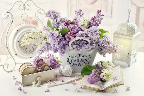 Renkli leylak çiçekleri olan güzel bir kompozisyon metal kovada döküntü şık bir iç mekan.