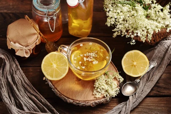 Glass of healthy elderberry blossom tea with honey and lemon for cold and immunity