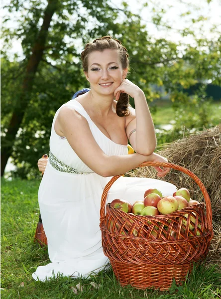 Die Braut mit einem Korb voller Äpfel Stockfoto