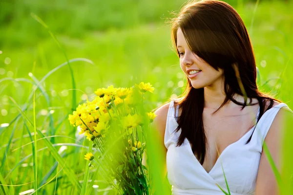 Mulher adorável com flores em pensamento — Fotografia de Stock