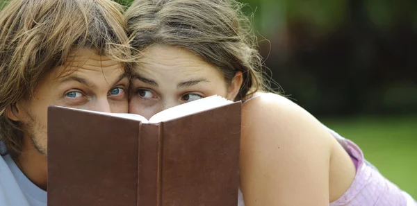 Um namorado e namorada lendo um livro em um parque — Fotografia de Stock