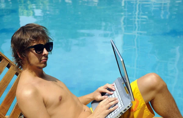 Jonge man zonnebaden bij zwembad — Stockfoto