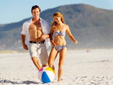 beach couple playing with ball clipart