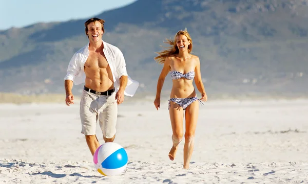 Пляжна пара грає з м'ячем — стокове фото