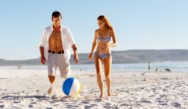 Пляжна пара грає з м'ячем — стокове фото