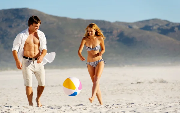 Beach couple playing with ball — Stock Photo, Image