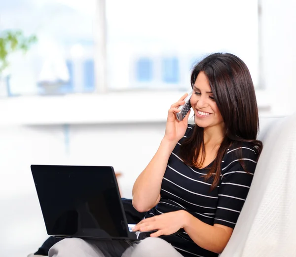 Woman talking on the phone with laptop — Stock Photo, Image