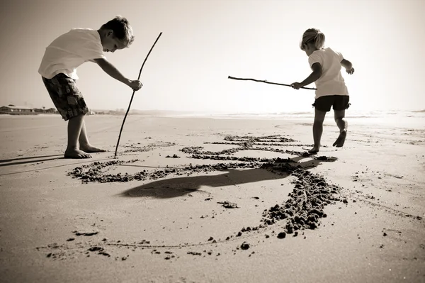 Kids writing in sand — Stockfoto