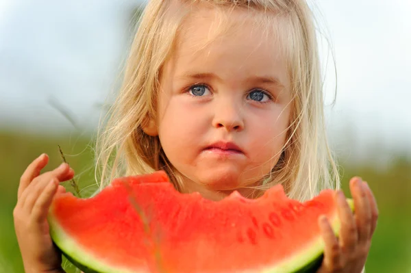Healthy child eating watermelon