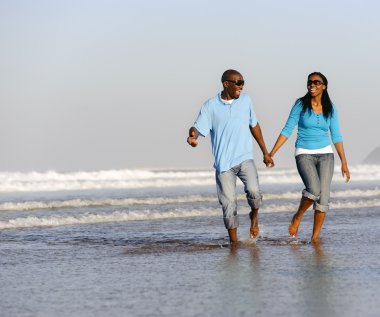 Kumsalda yürüyen çift.