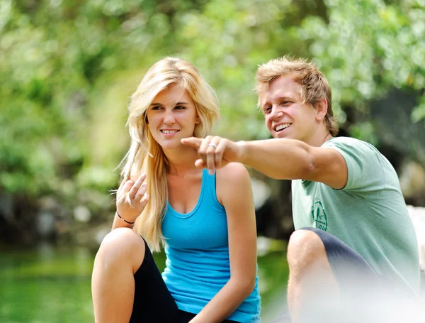 Blonde paar zitten samen op het meer — Stockfoto