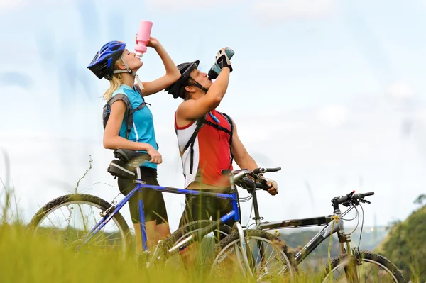 Mountain bike pareja bebiendo — Foto de Stock