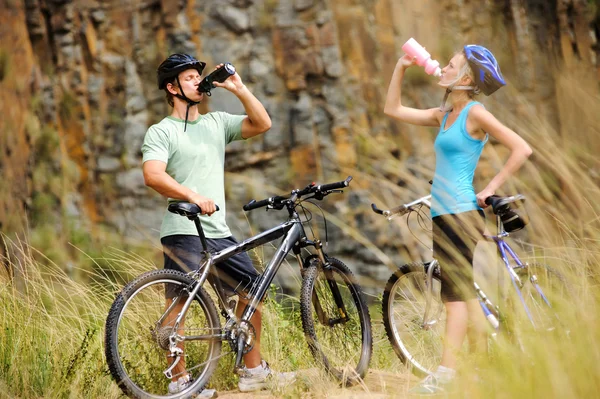 Mountain bike pareja bebiendo — Foto de Stock