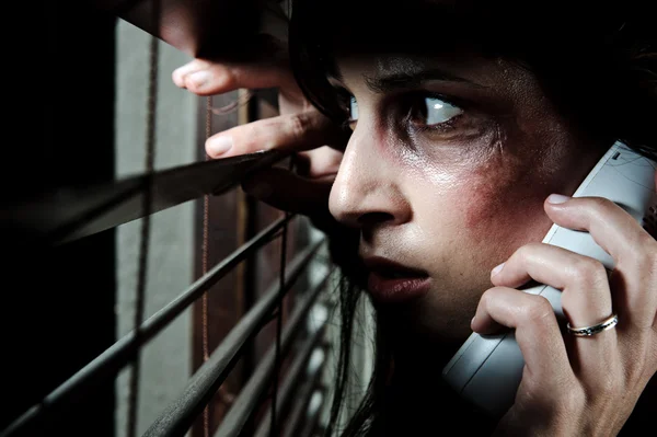 Ängstliche Frau, die durch die Jalousien schaut, um zu sehen, ob ihr Mann zu Hause ist, während sie um Hilfe ruft — Stockbild Hilferuf nach Konzept für häusliche Gewalt — Stockfoto