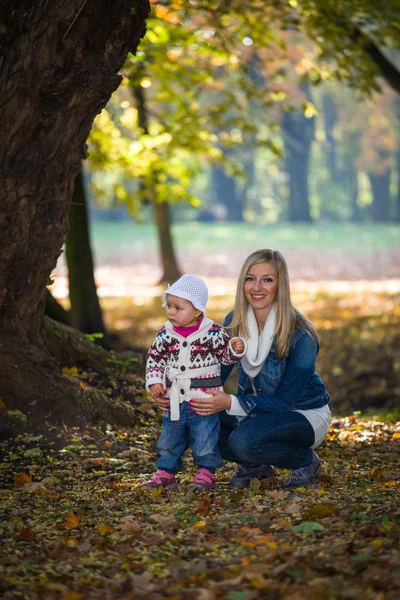Infant baby girl in golden autumn park — Stock Photo, Image