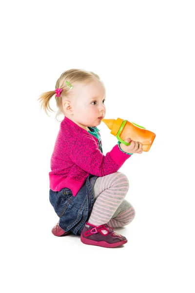 Meisje van de baby het drinken van thee uit fles — Stockfoto