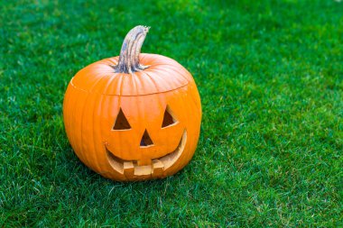 Jack-o-lantern yeşil çimenlerin üzerinde