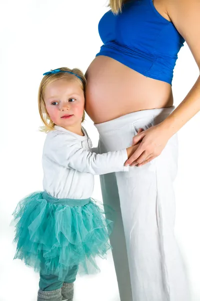 Pregnant woman with 2 yo daughter on white — Stock Photo, Image