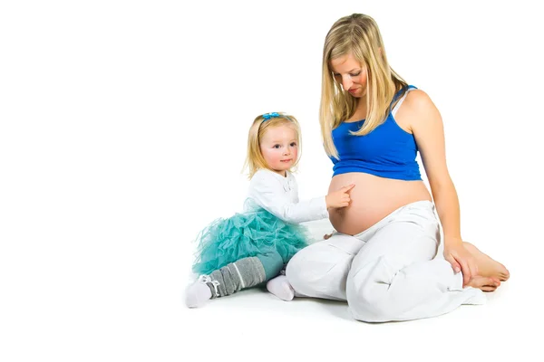 Schwangere Frau mit 2-jähriger Tochter auf weißem Grund — Stockfoto