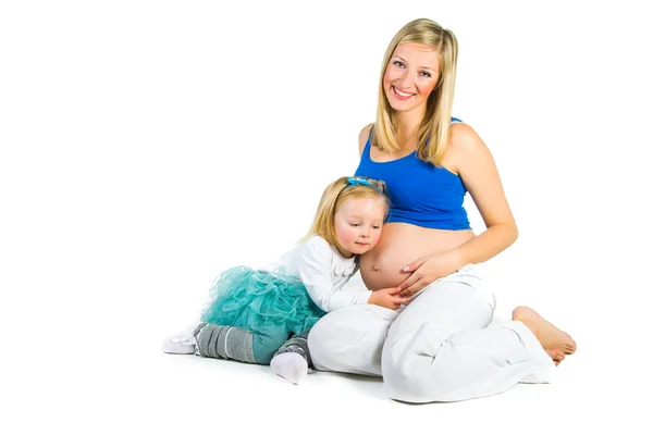 Беременная женщина с 2-летней дочерью на белом — стоковое фото