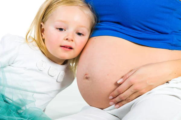 Pregnant woman with 2 yo daughter on white — Stock Photo, Image