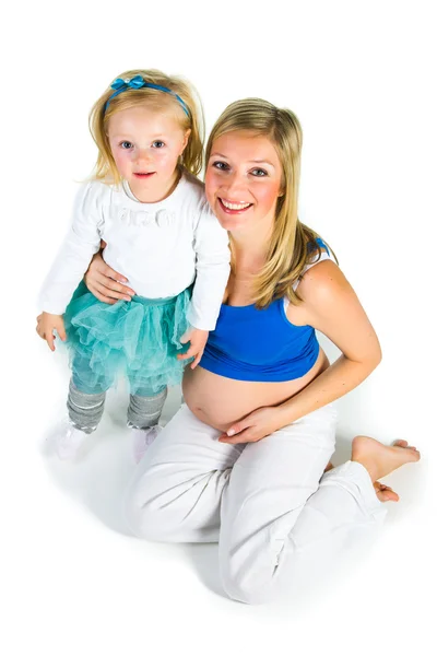 Pregnant woman with 2 yo daughter on white — Stock Photo, Image