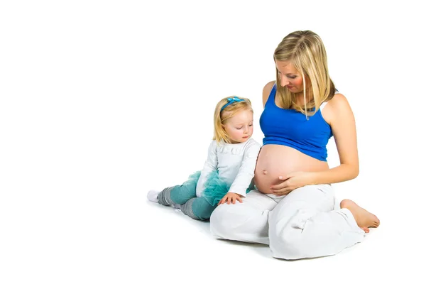 Pregnant woman with 2 yo daughter on white — Stock Photo, Image