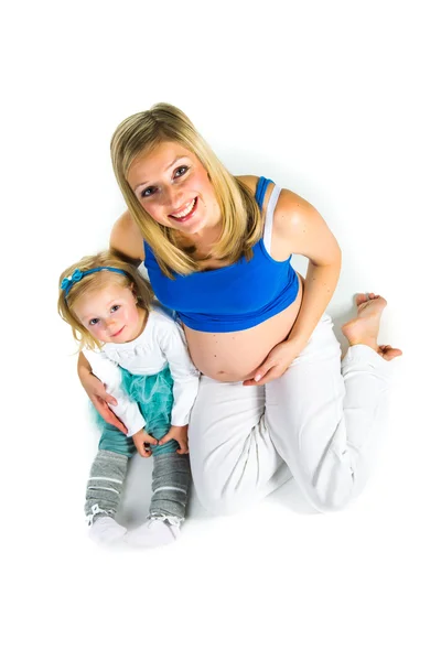 Pregnant woman with 2 yo daughter on white — Stock Photo, Image