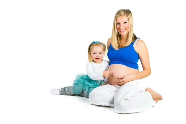 Schwangere Frau mit 2-jähriger Tochter auf weißem Grund — Stockfoto