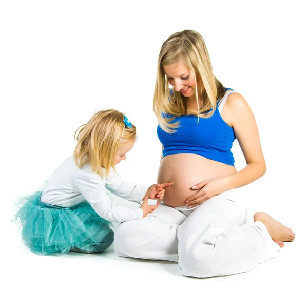 Pregnant woman with 2 yo daughter on white — Stock Photo, Image