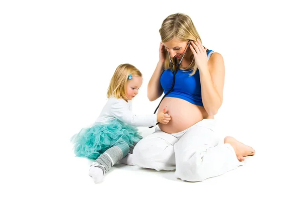 Pregnant woman with 2 yo daughter on white — Stock Photo, Image