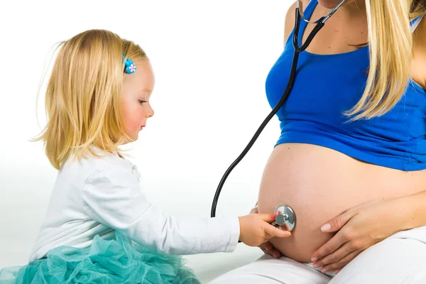 Pregnant woman with 2 yo daughter on white — Stock Photo, Image