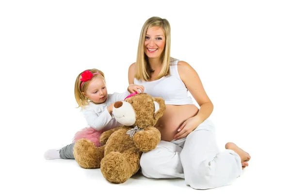 Pregnant woman with 2 yo daughter on white — Stock Photo, Image