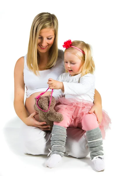 Pregnant woman with 2 yo daughter on white — Stock Photo, Image