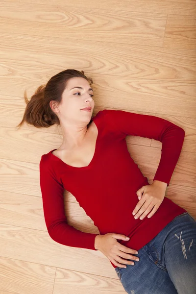 Kvinna liggande på golvet och tänkande — Stockfoto
