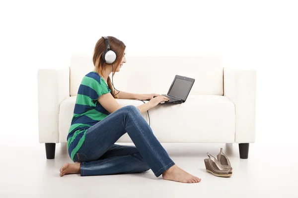 Musik hören und einen Laptop benutzen — Stockfoto