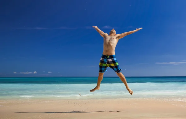 Uomo che salta sulla spiaggia — Foto Stock